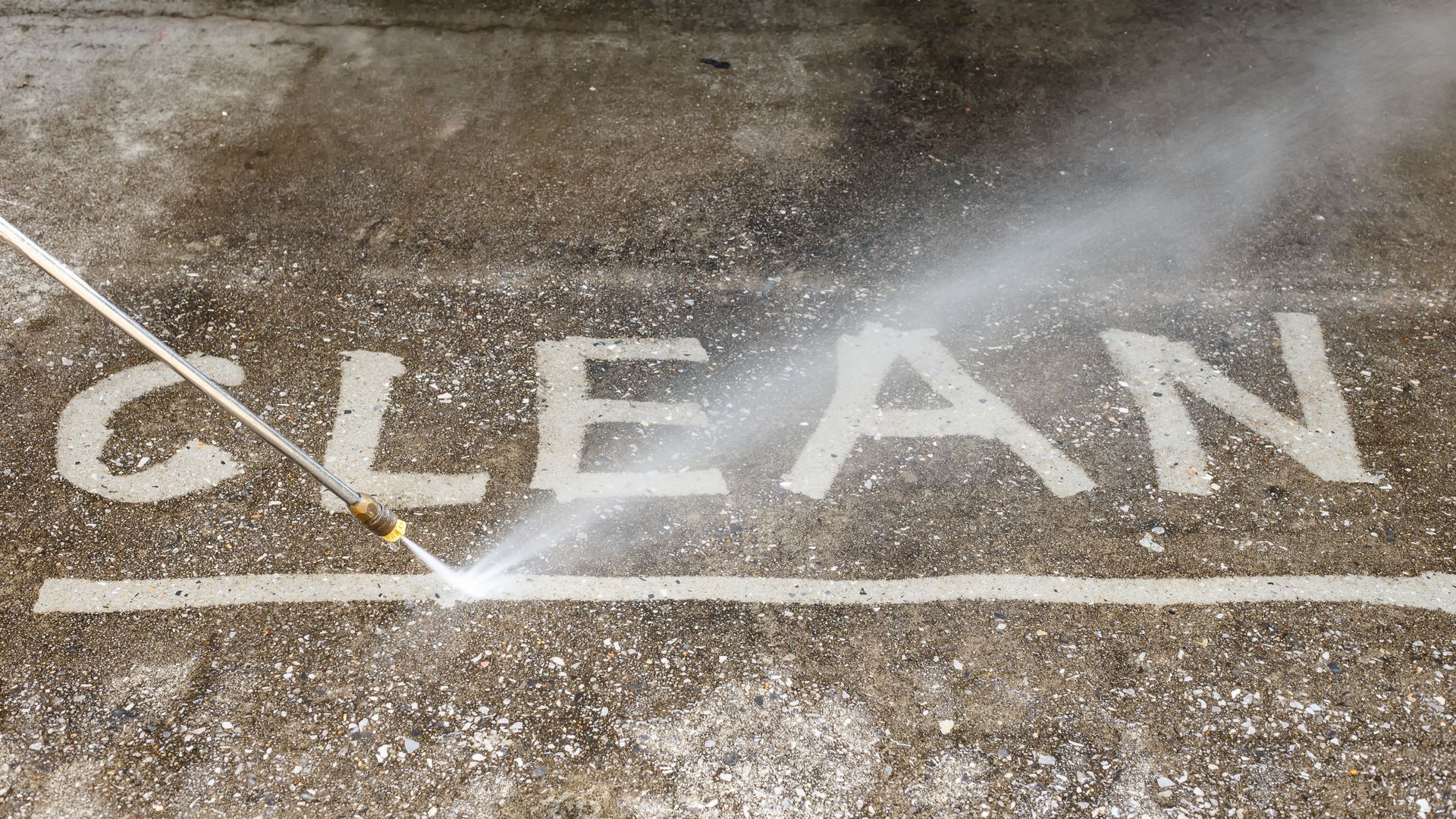 A power washer spraying the word 