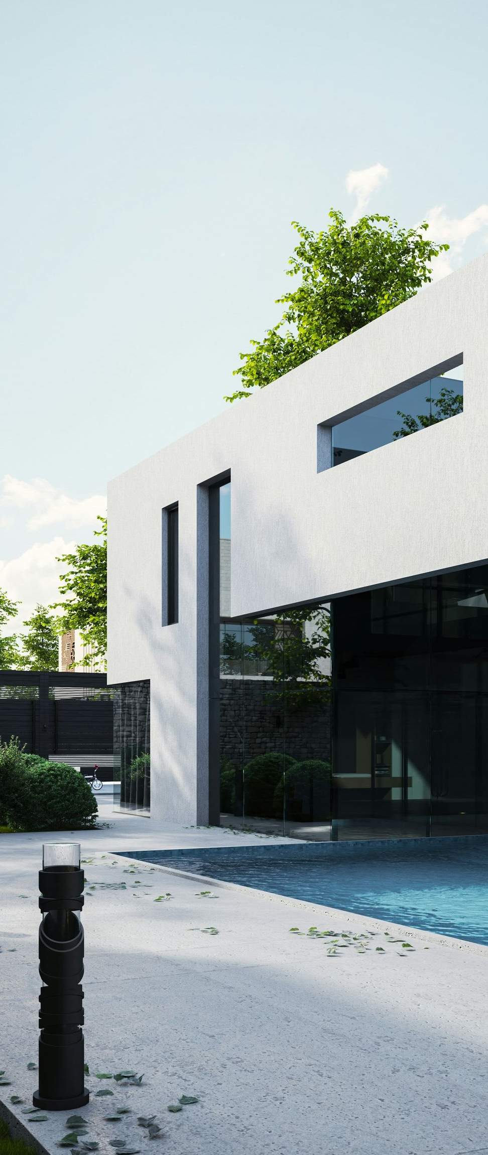 A modern two-story villa with white walls and glass walls overlooking a private swimming pool and a gravel courtyard.