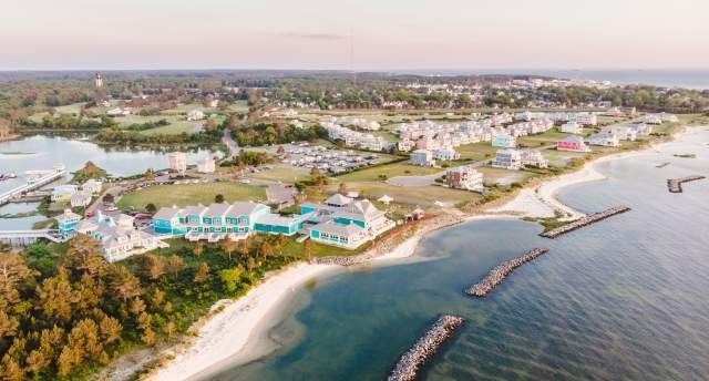 Coastal town with turquoise buildings, sandy beaches, and calm blue water.