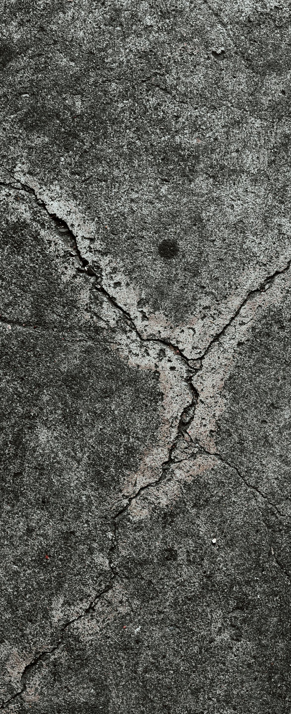Cracked gray stone surface with a Y-shaped fracture pattern