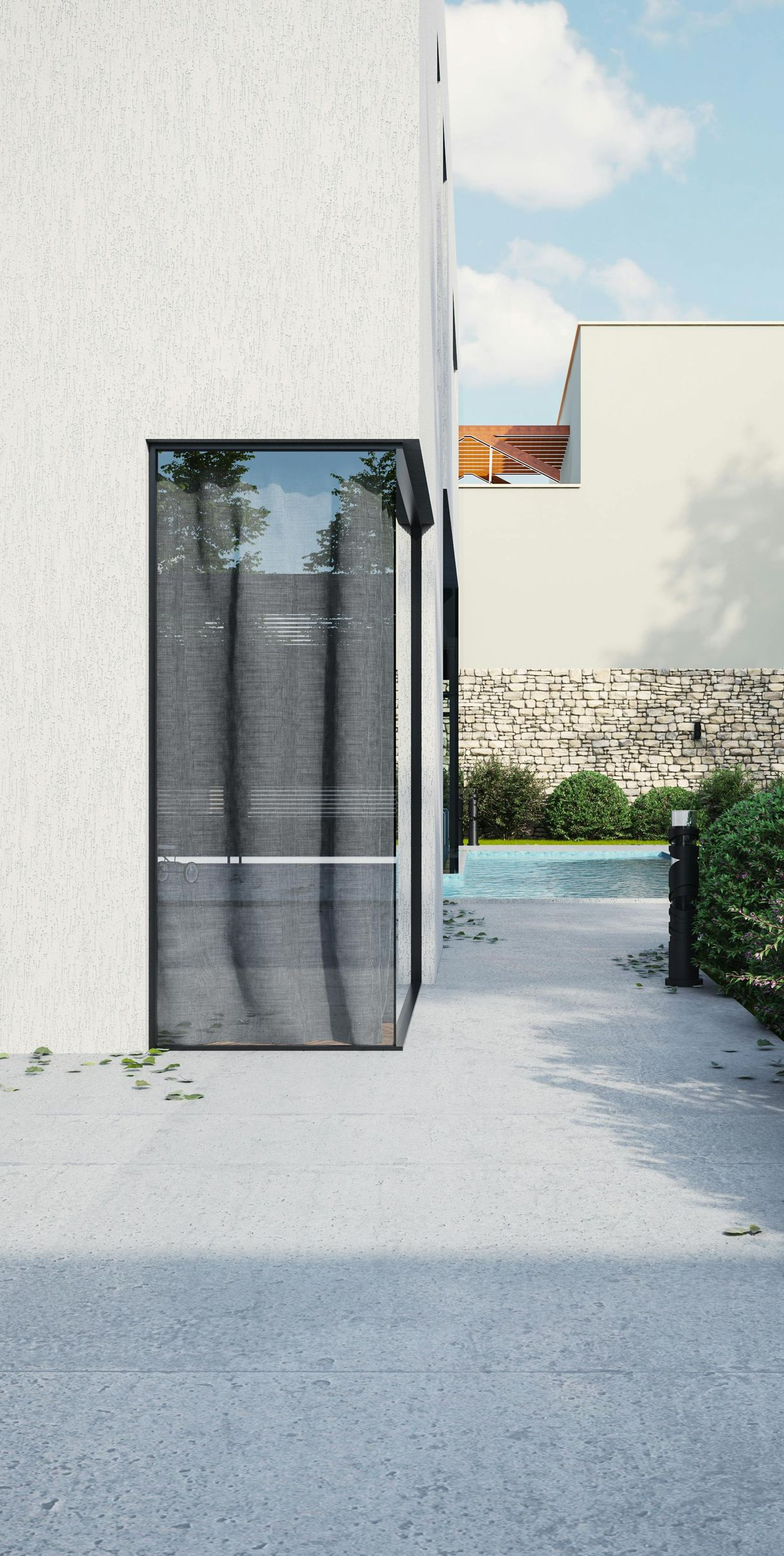 Modern white building with glass entry, stone path, pool, and plants on a sunny day.