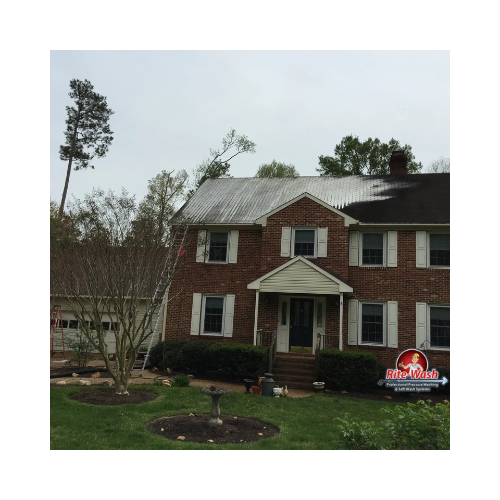 A person is using a high pressure washer to clean a wooden deck.