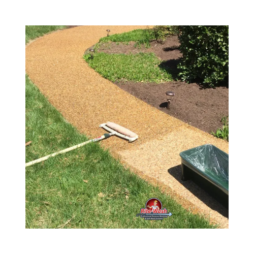 A man is using a high pressure washer to clean a patio.