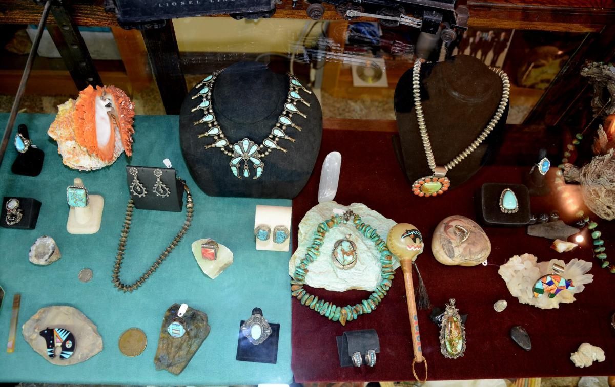 Jewelry display with necklaces, earrings, and rings featuring turquoise and other stones.