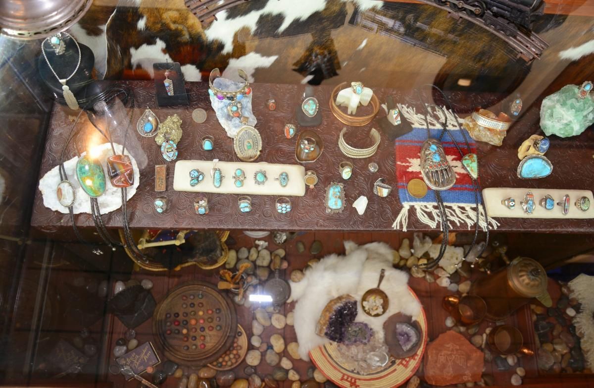 Display case with Southwestern jewelry and artifacts. Turquoise, beads, shells, and stones.
