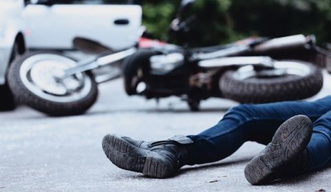 Motorcycle Injuries — Motorist On The Ground After The Accident in Visalia, CA