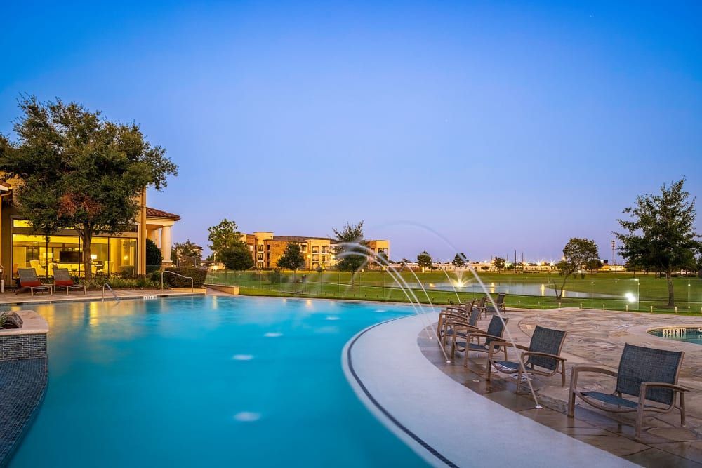 A large swimming pool with a fountain at Marquis at the Reserve in Katy, TX.