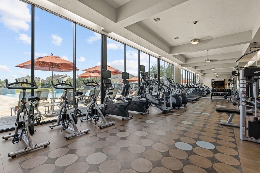 Spacious fitness center filled with lots of exercise equipment and oversized windows at Marquis at the Reserve in Katy, TX.