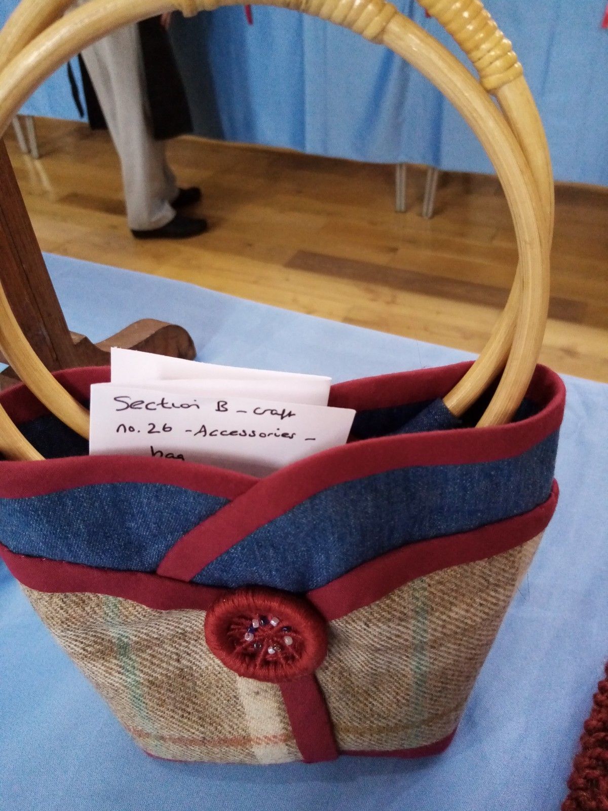 A blue and red purse with a wooden handle