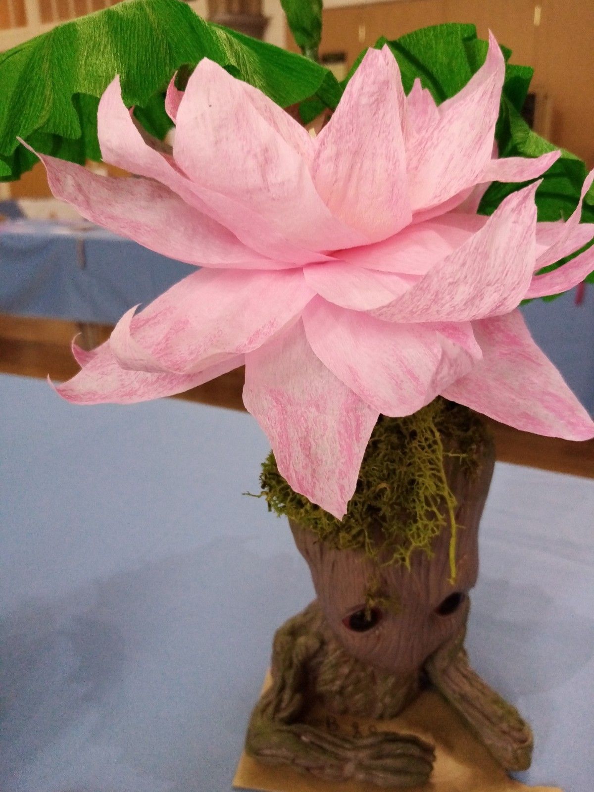 A tree trunk with a pink flower on top of it