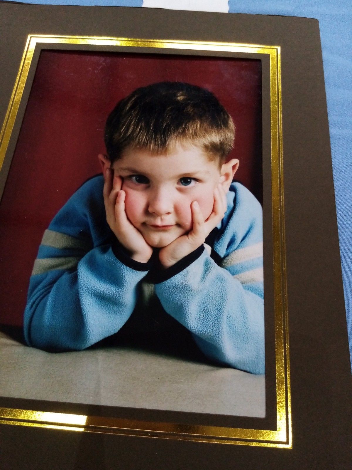 A picture of a young boy with his hands on his chin
