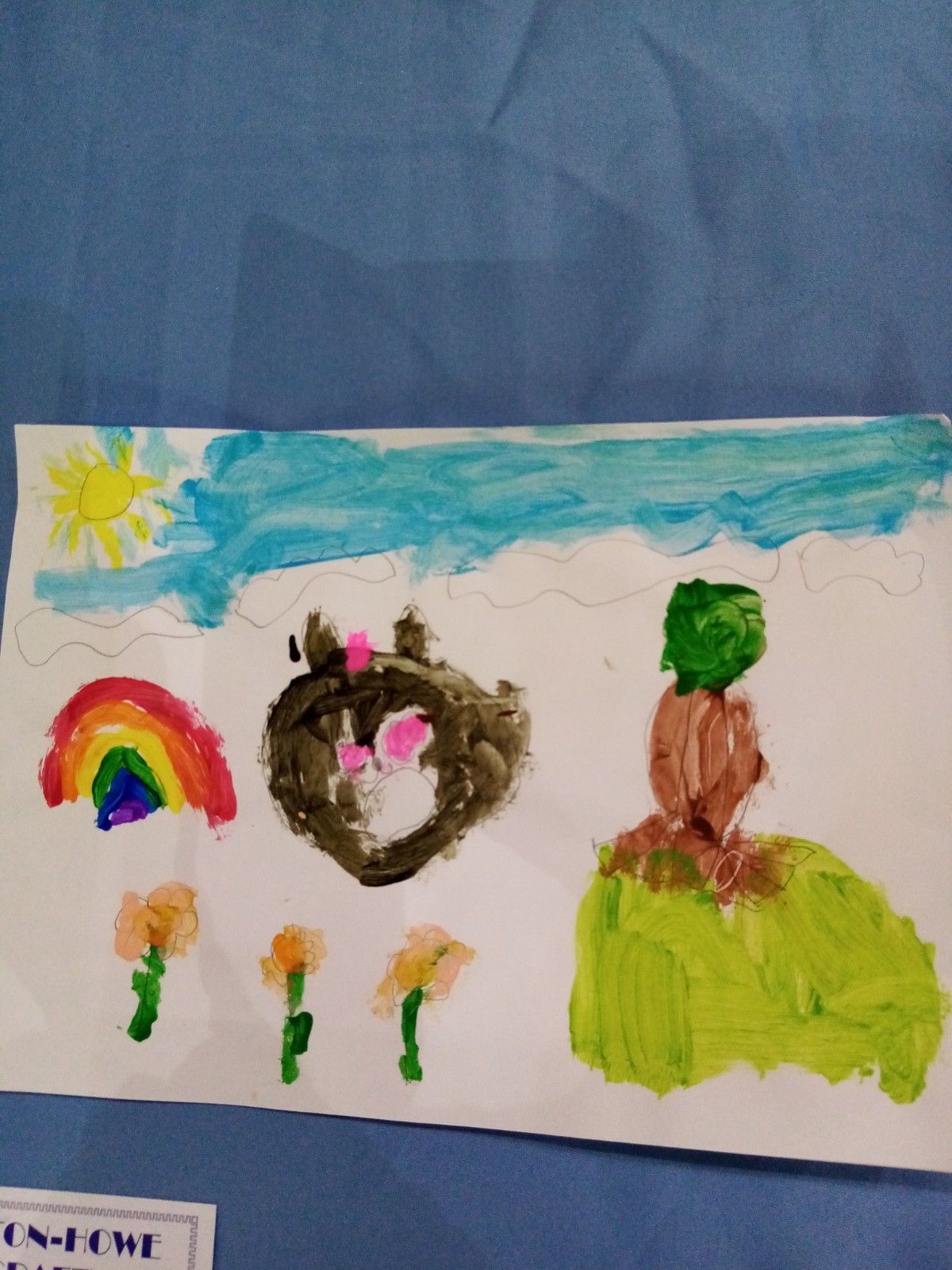 A child 's drawing of a rainbow and flowers