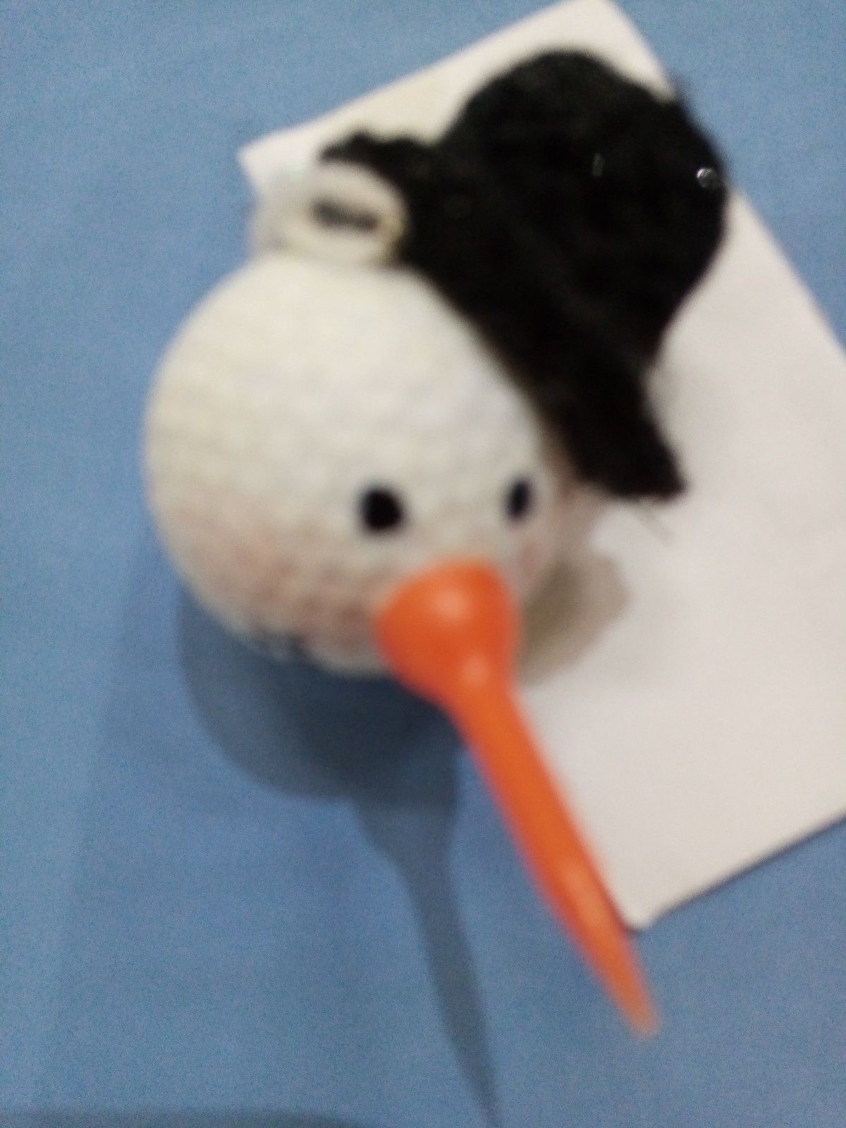 A crocheted bird with a long orange beak