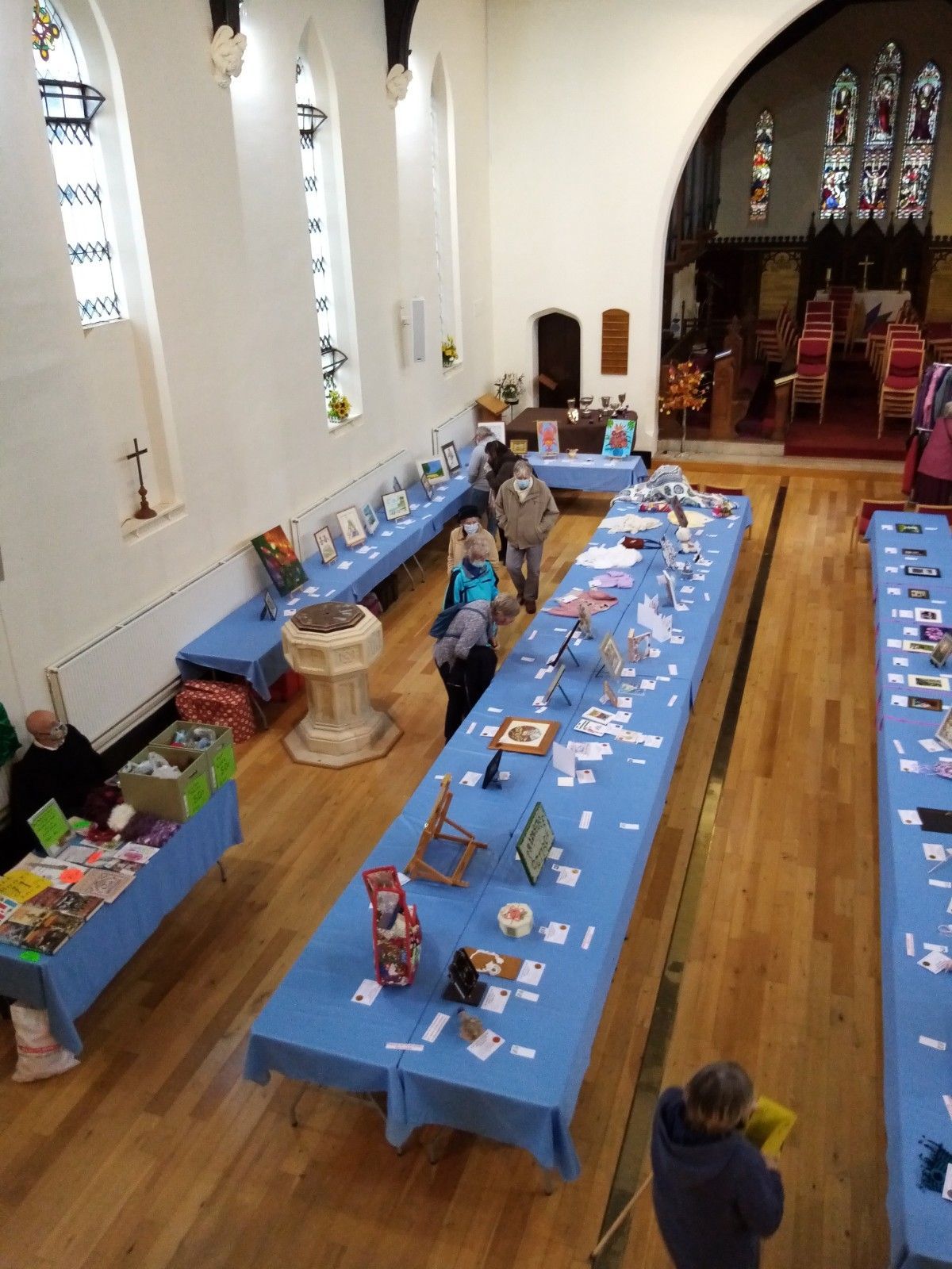 A group of people are standing around tables in a church.