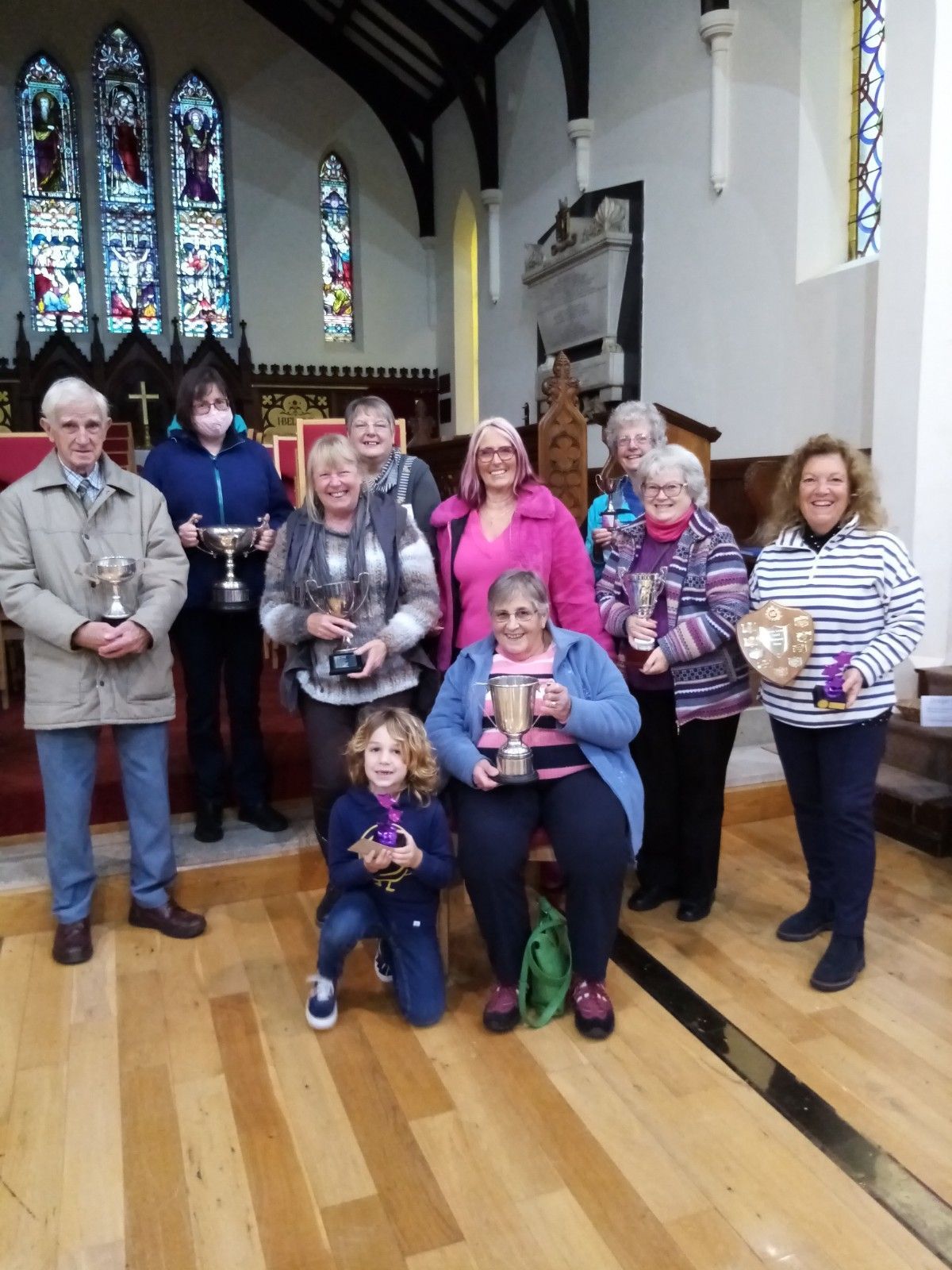 A group of people holding trophies in a church