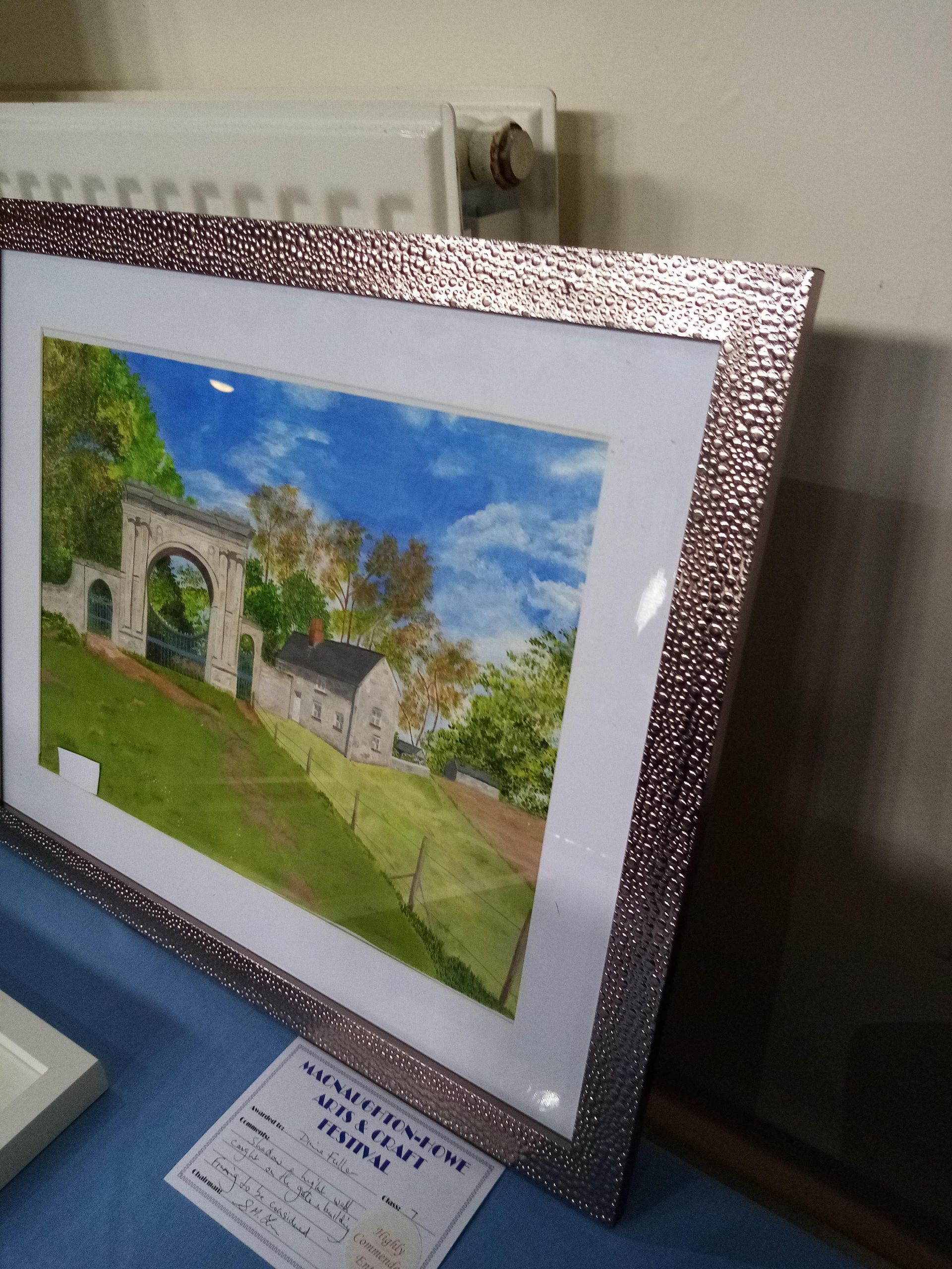 A framed picture of a house in a park