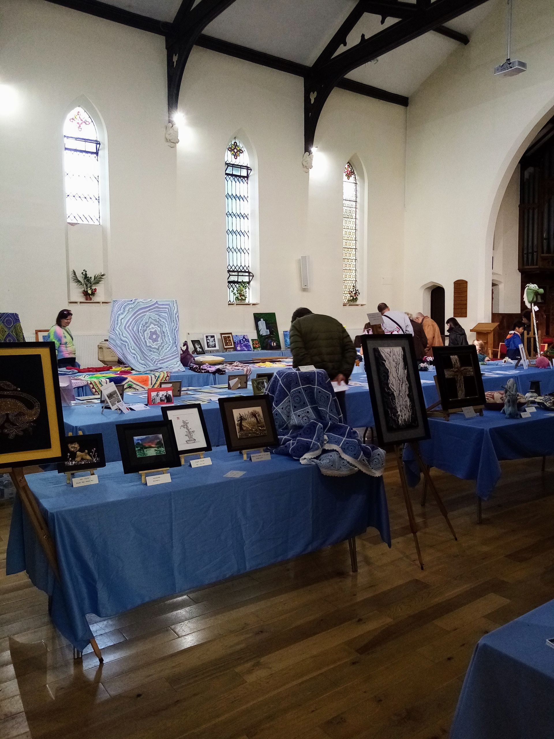A group of people are standing around tables in a church.