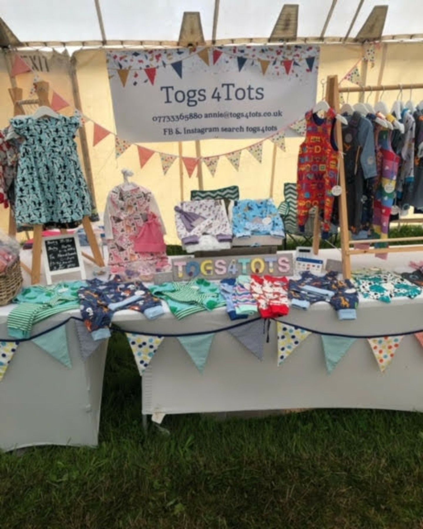 A table with a sign that says ' togs 4 tots ' on it