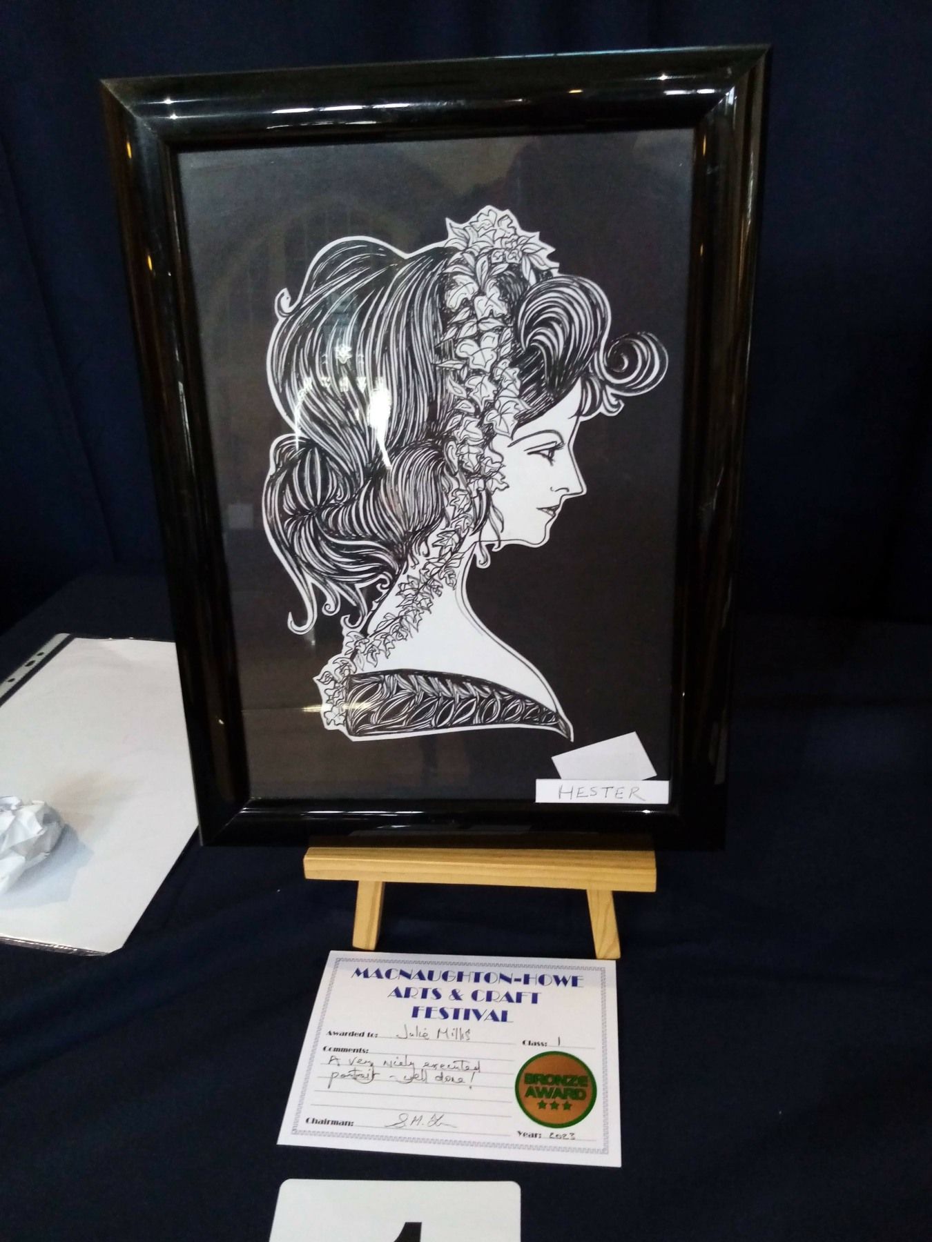 A framed picture of a woman 's head is on an easel.