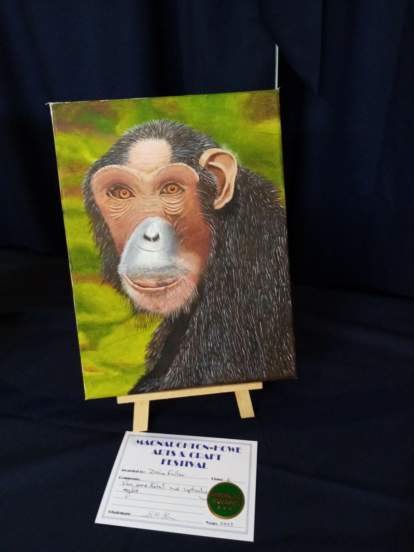 A painting of a chimpanzee with a certificate next to it
