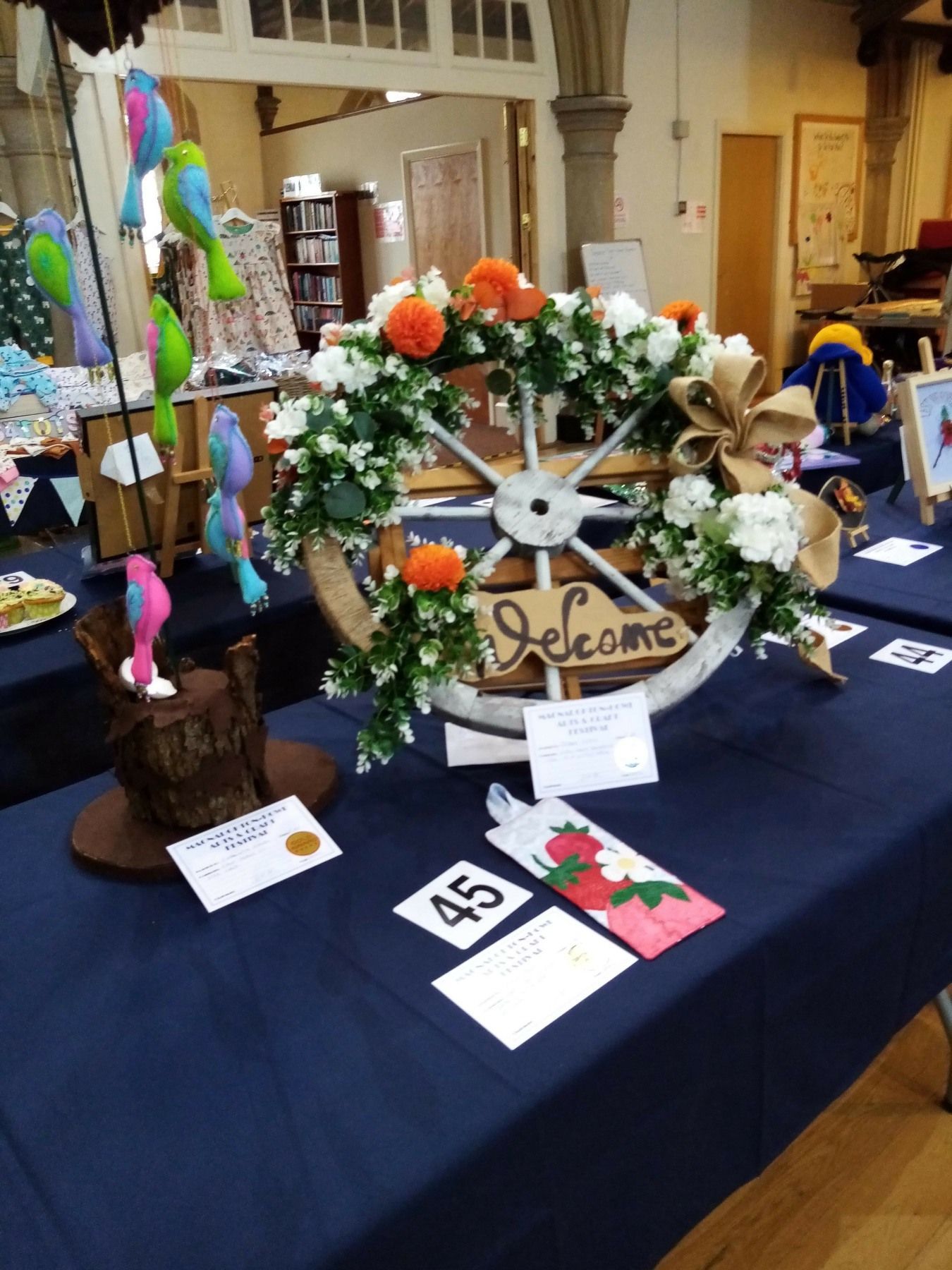 A table with a welcome sign and a wreath on it