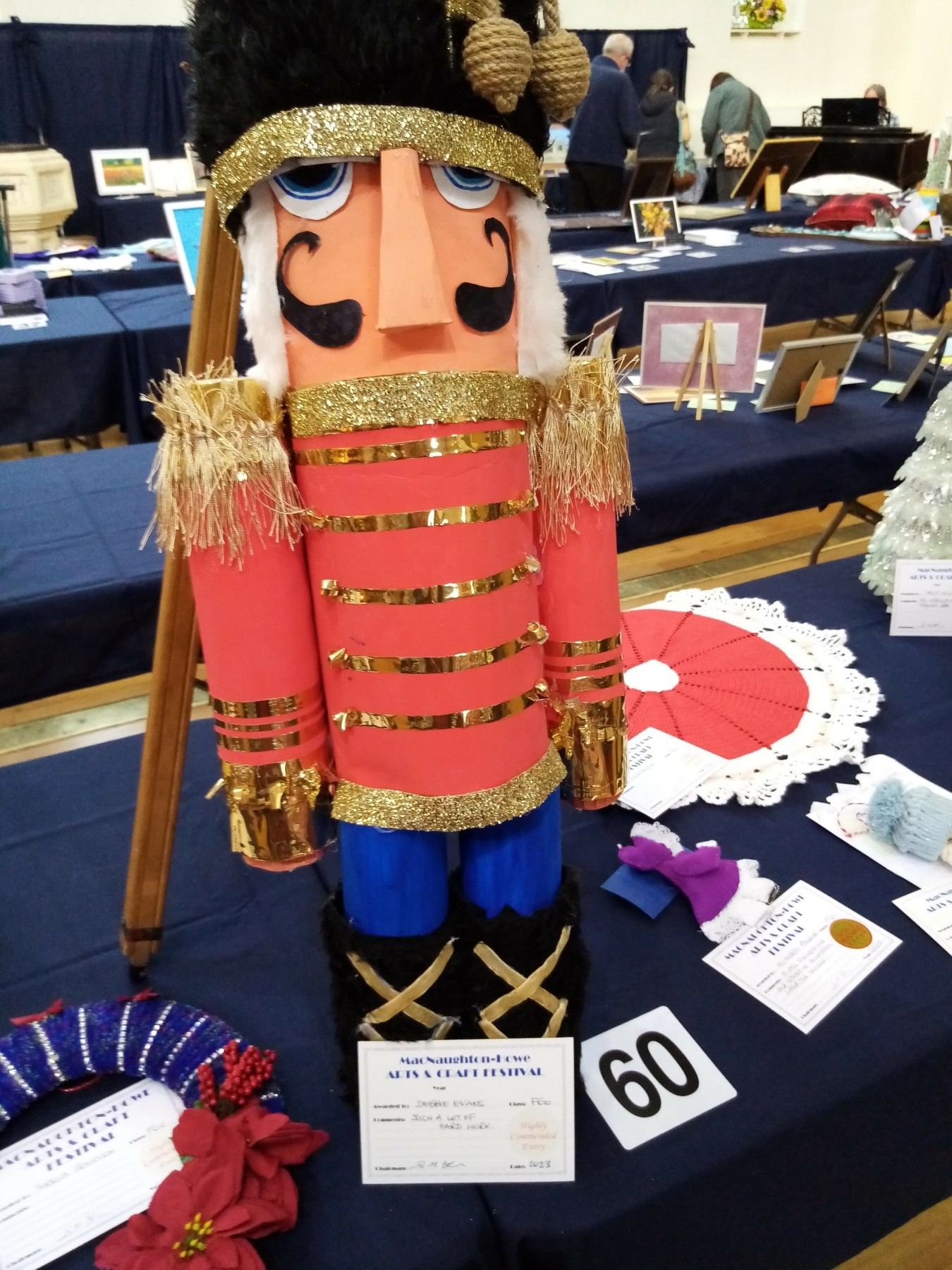 A nutcracker is sitting on a table next to a sign that says 60
