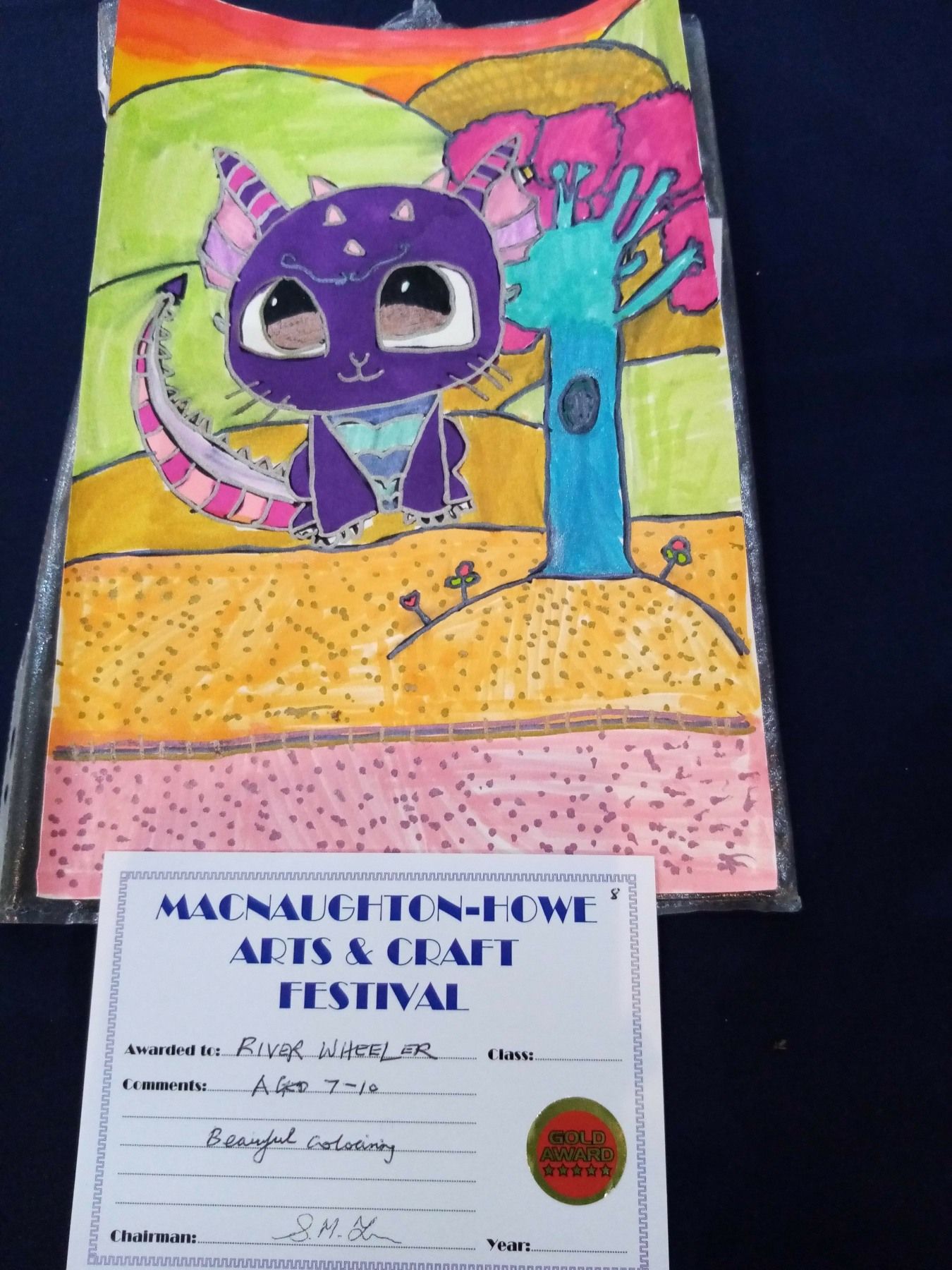 A child 's drawing of a purple cat with a certificate that says arts & craft festival