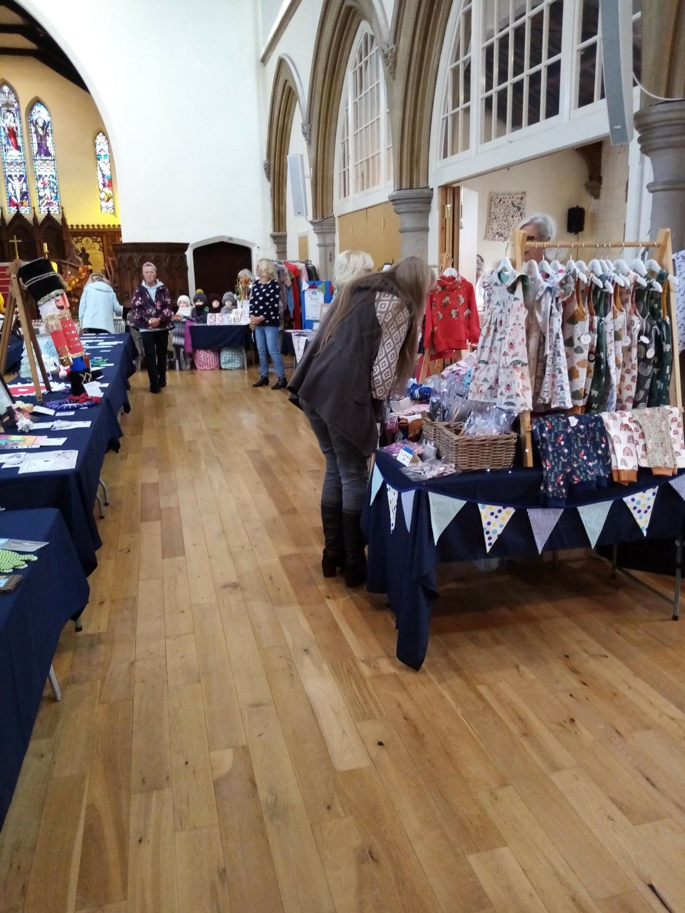 A woman is looking at a table at a market in a church.