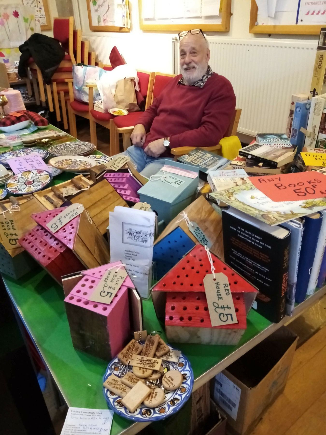 A man is sitting in a chair in front of a table full of boxes