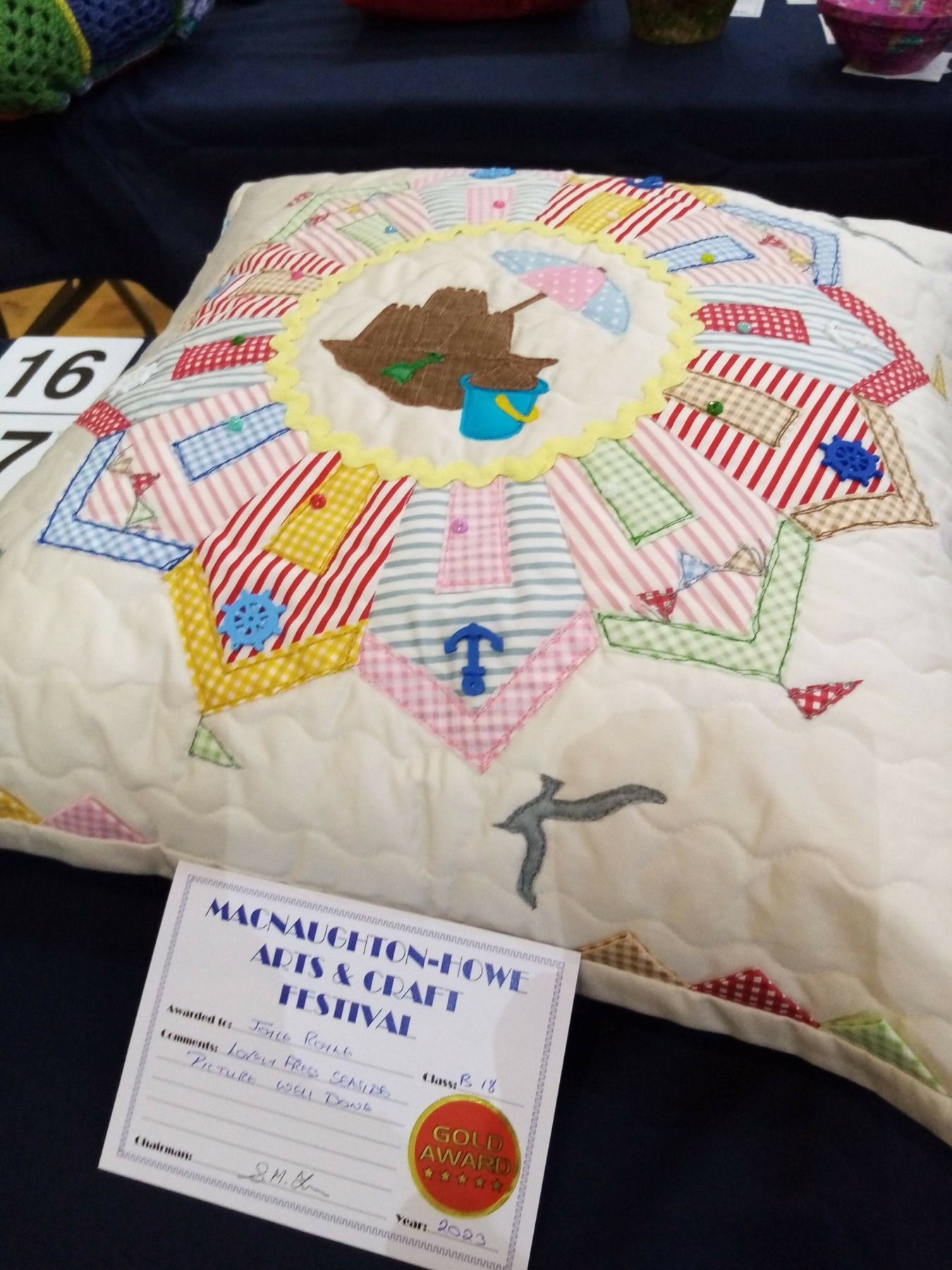 A quilted pillow with a certificate that says national craft festival