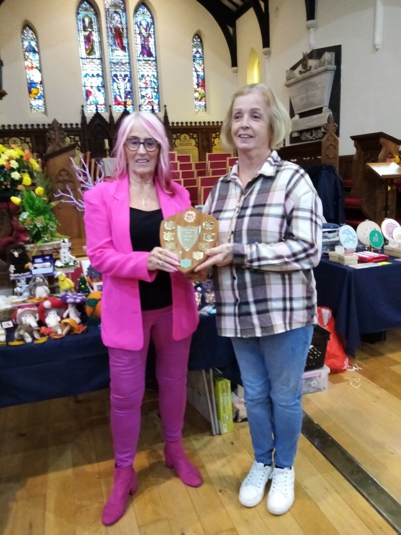 Two women standing next to each other holding a plaque