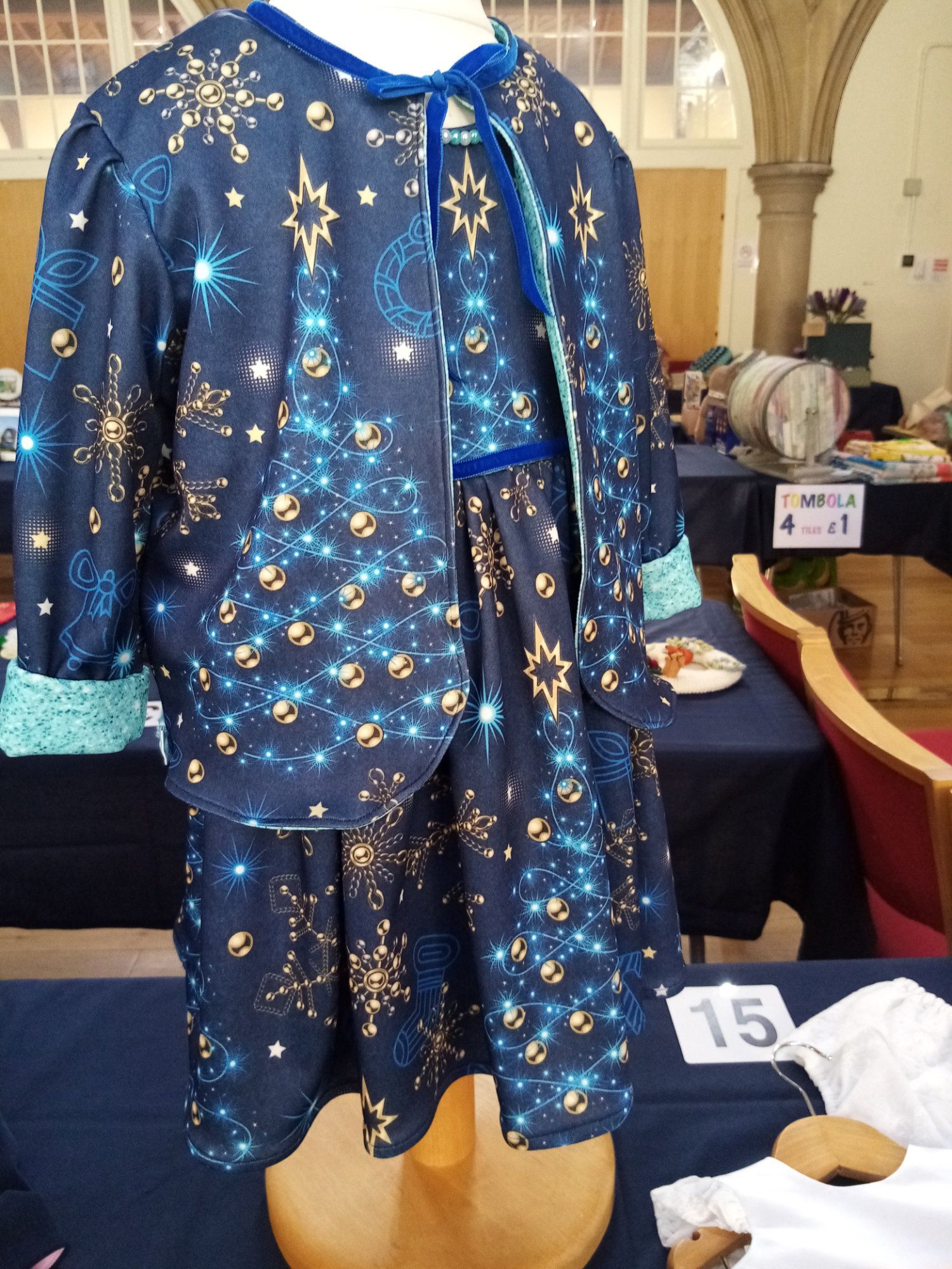 A mannequin is wearing a blue dress with gold stars on it