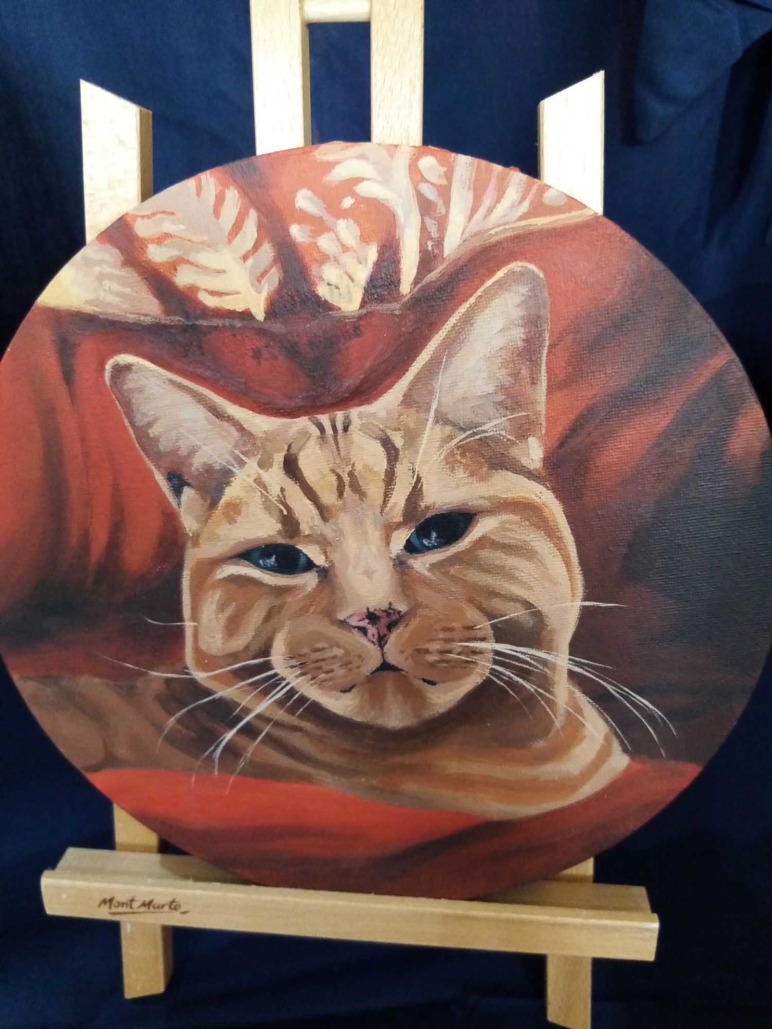 A painting of a cat on a wooden easel