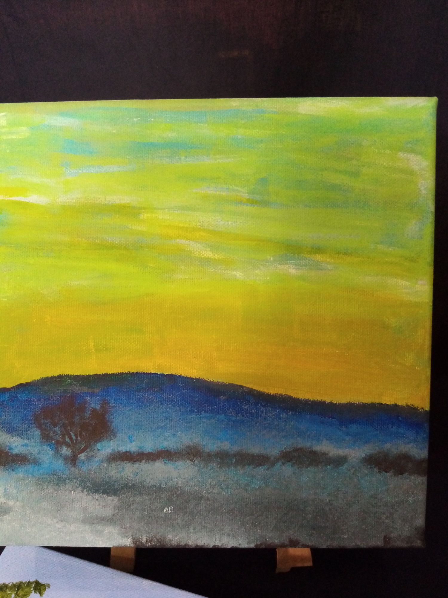 A painting of a sunset with a tree in the foreground