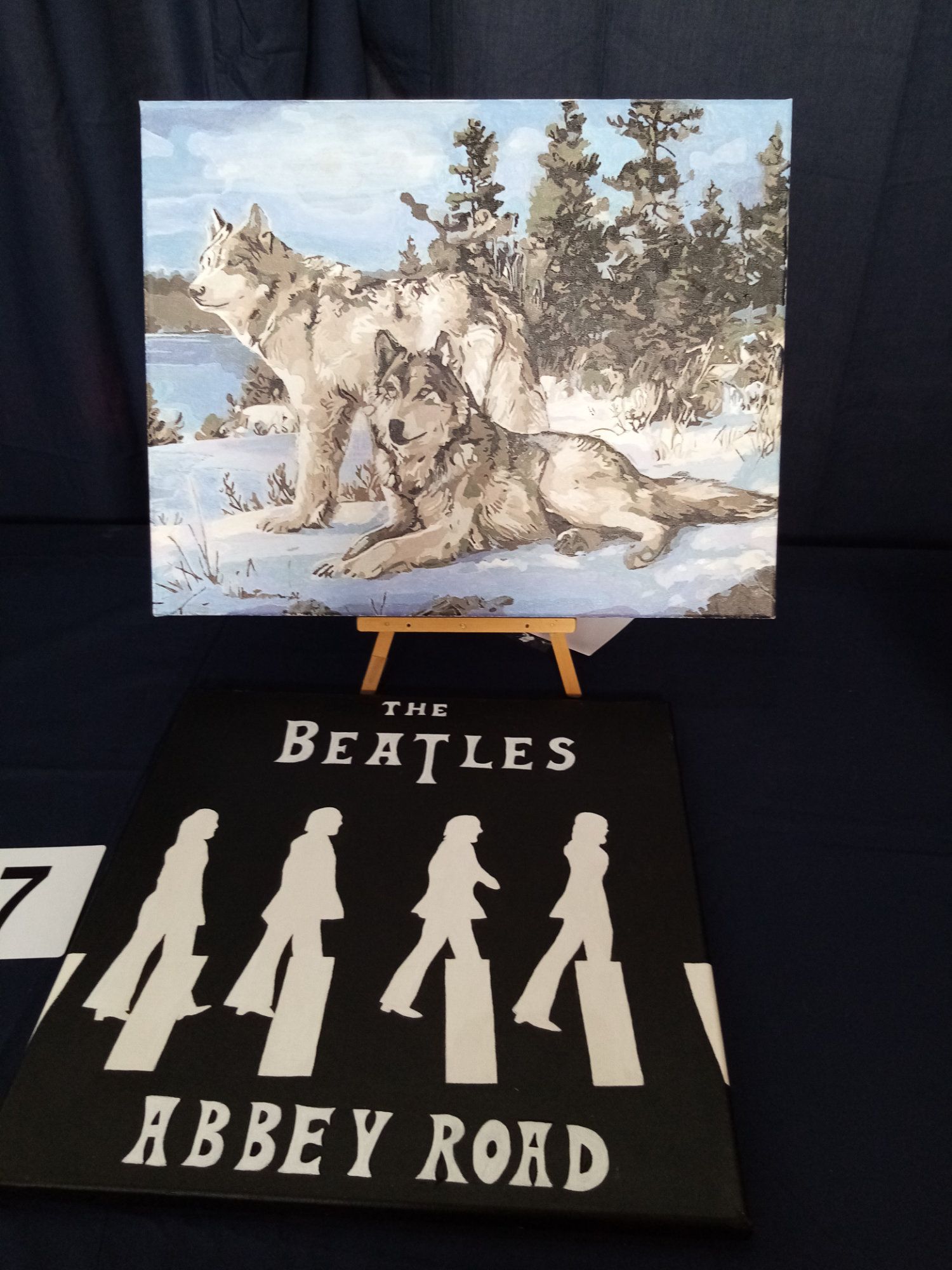 A painting of wolves next to a beatles abbey road sign