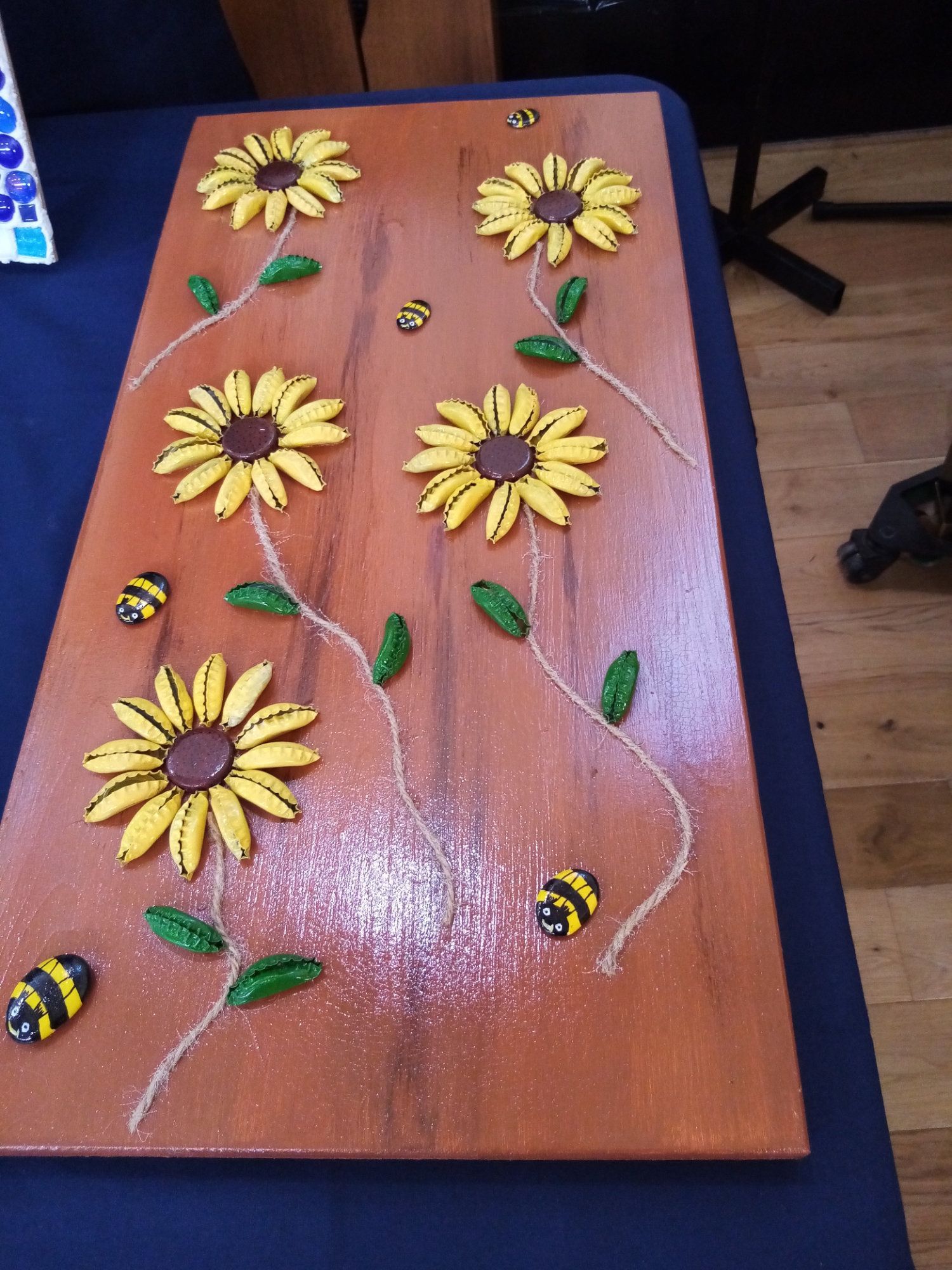 A wooden board with flowers and bees on it
