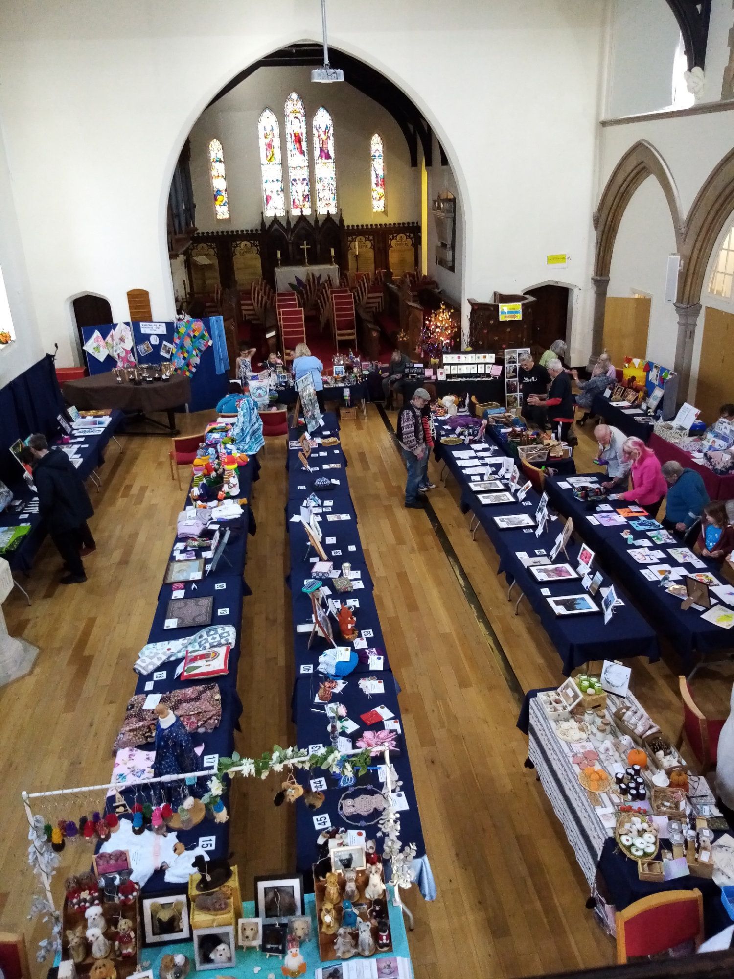 A group of people are sitting at long tables in a church.