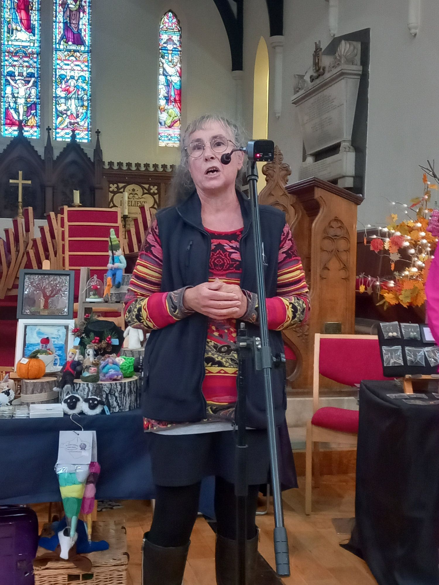 A woman is standing in front of a microphone in a church