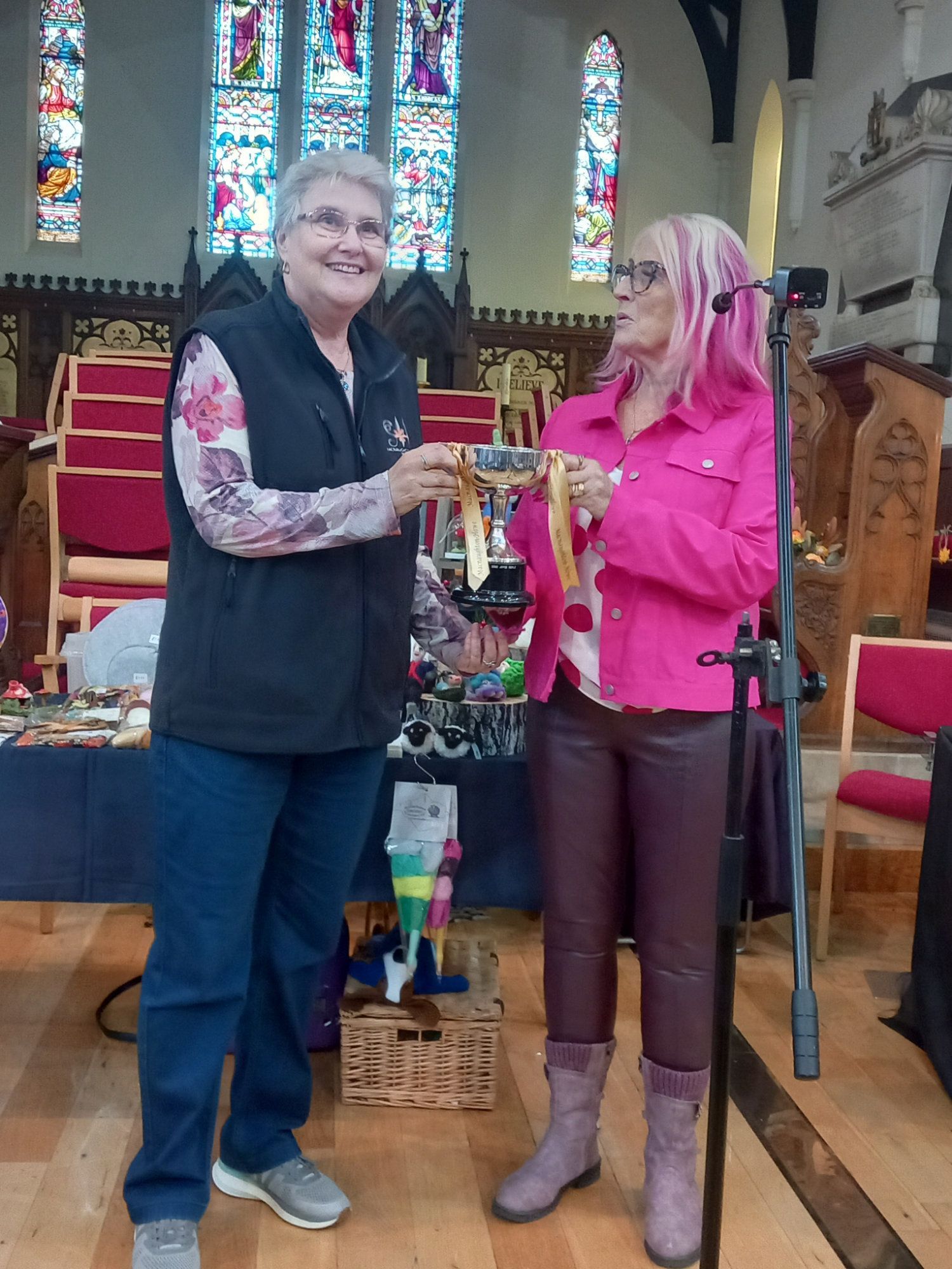 Two women are standing next to each other in a church.