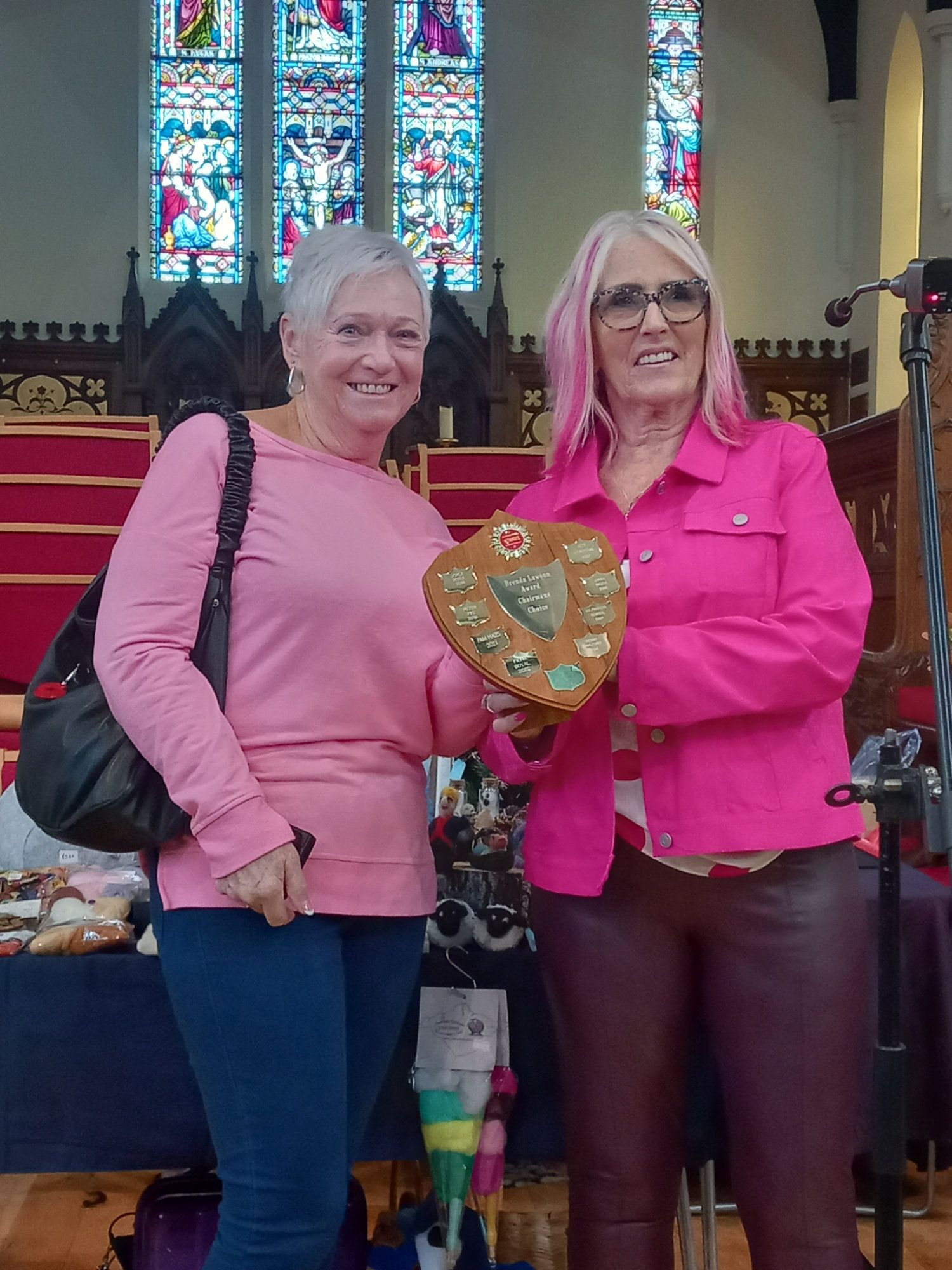 Two women standing next to each other holding a plaque