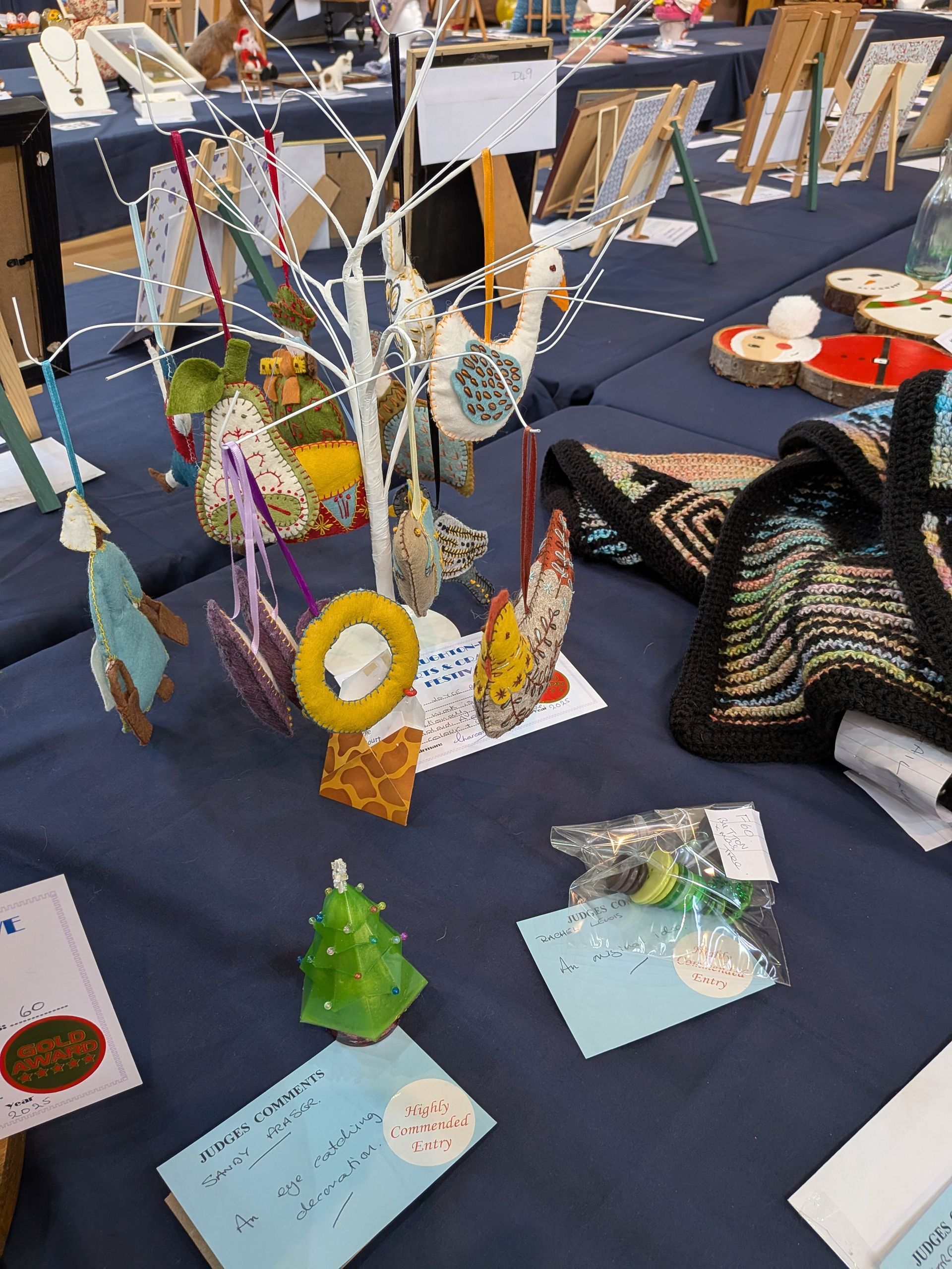 Handmade ornaments and crafts displayed on a blue table at a market.
