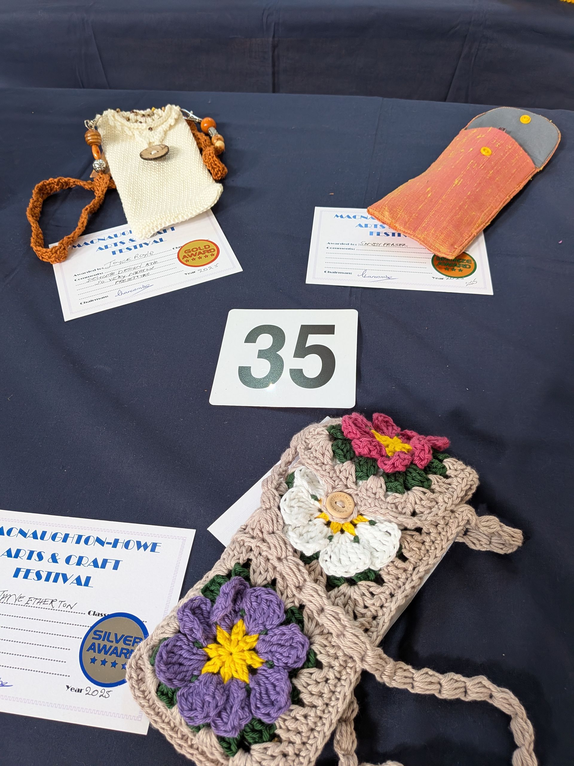 Three handmade bags and tag displayed on a blue tablecloth, numbered 35.