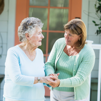 elderly woman and adult woman hand in hand