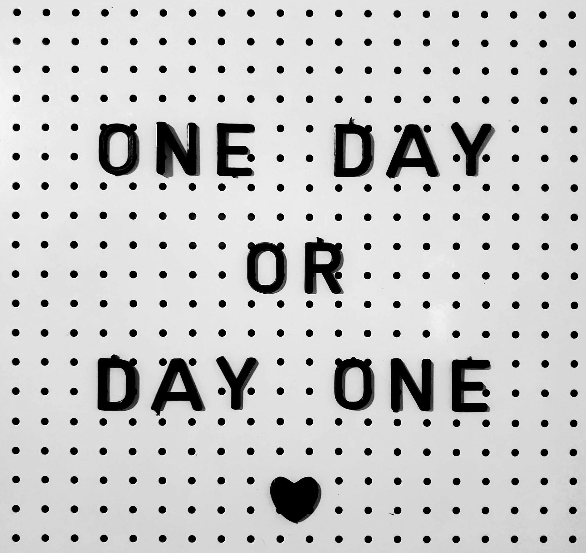 A sign that says one day or day one