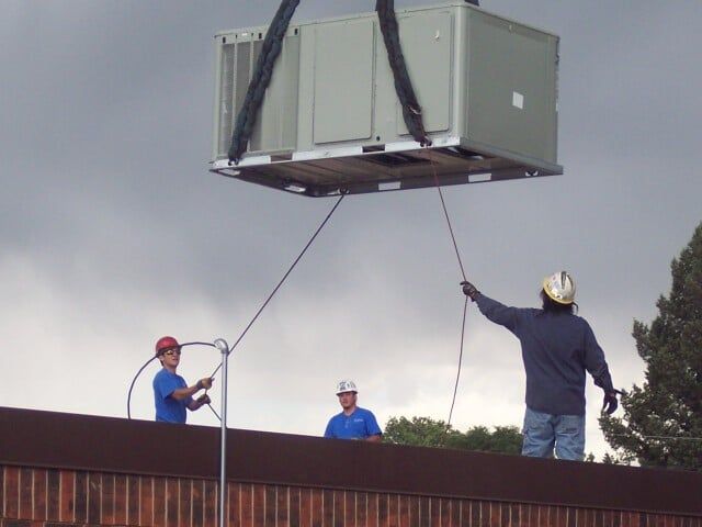Three men lifting hvac - AC repairs in Trinidad, CO
