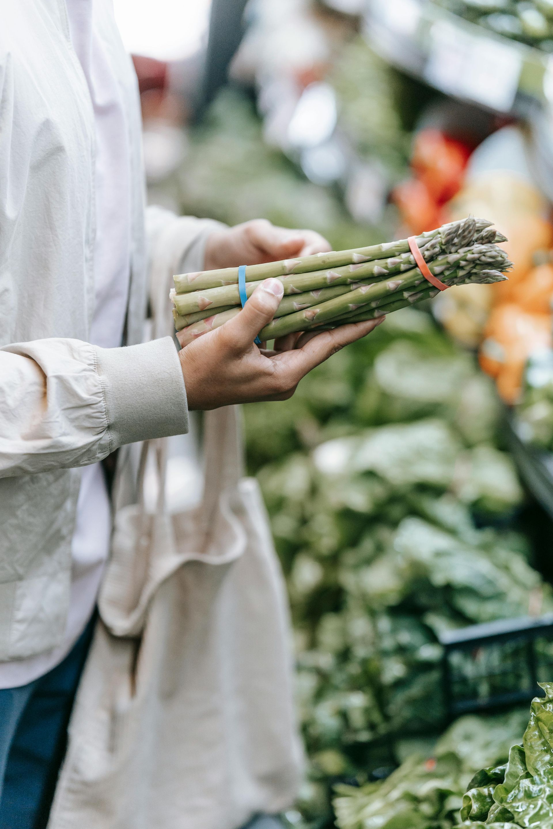 A person holding spears of asparagus.