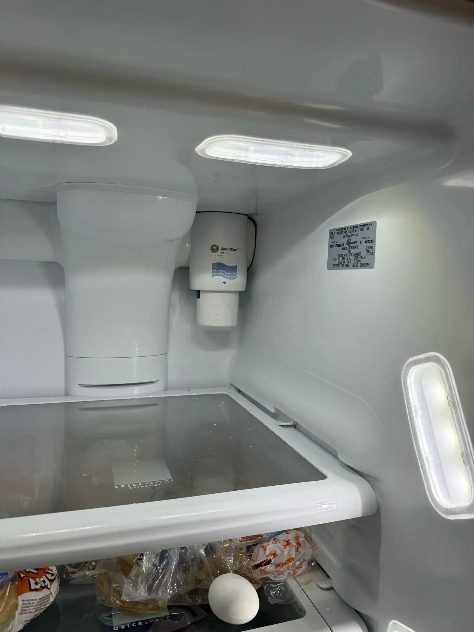 The inside of an empty refrigerator with eggs on the bottom shelf.