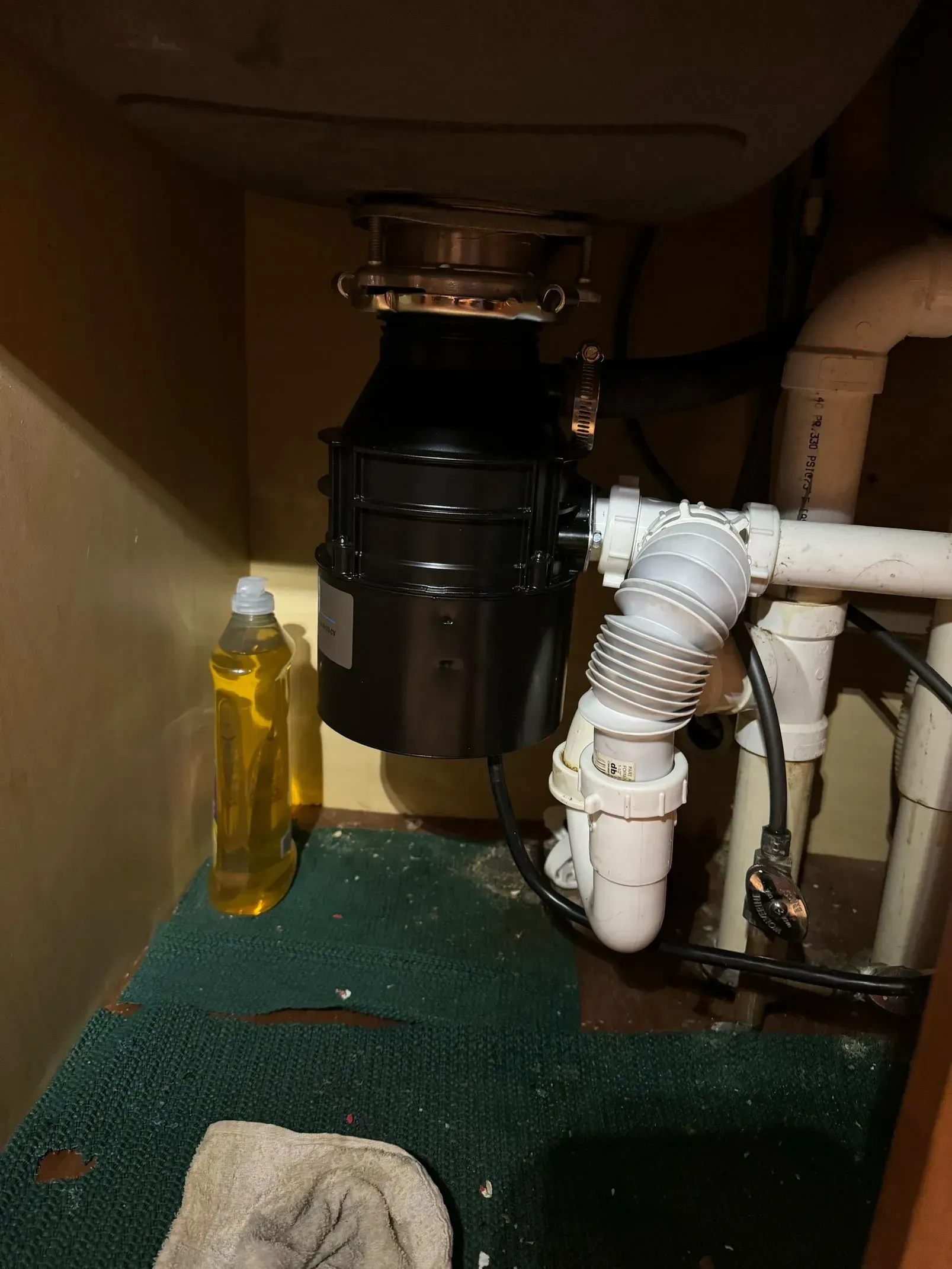 A garbage disposal unit installed under a kitchen sink.