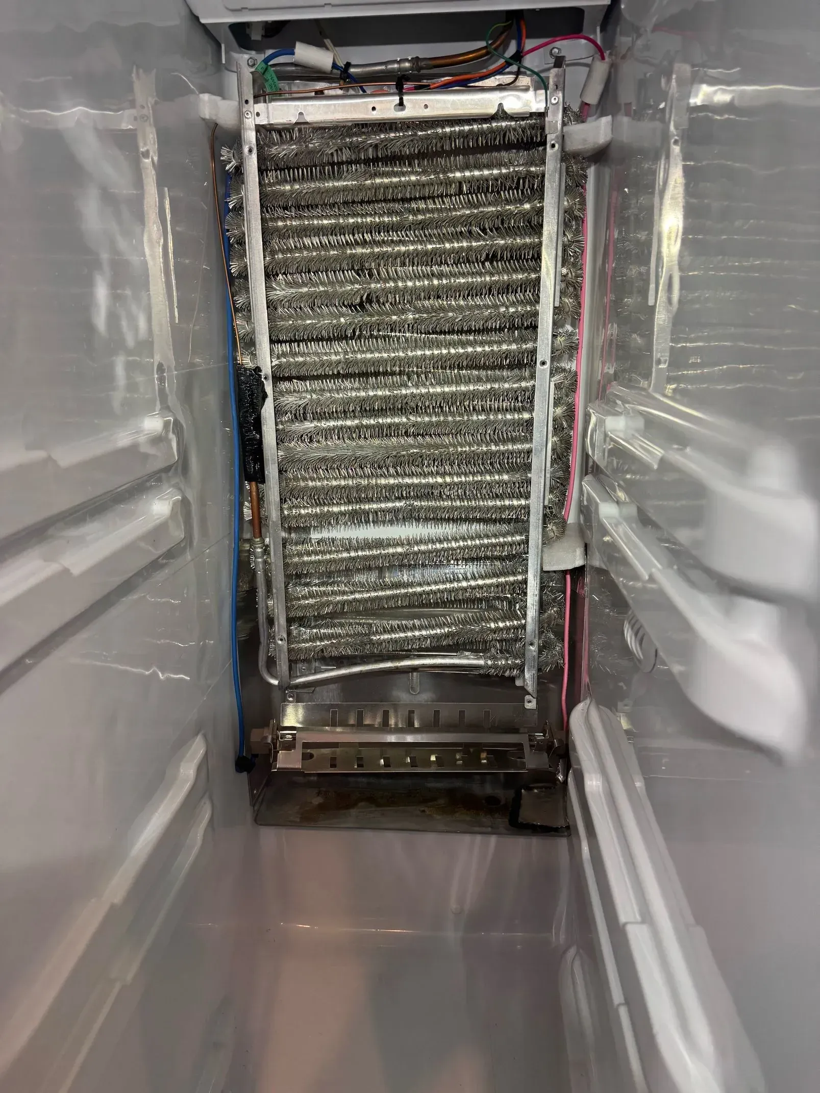 The inside of a refrigerator with a lot of ice in it.
