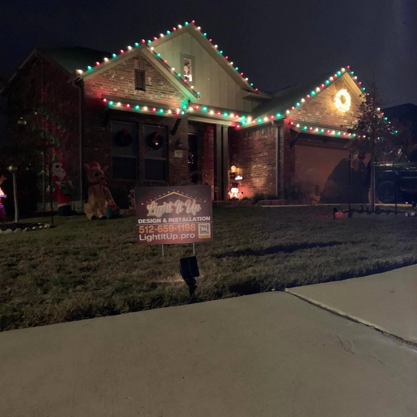 House decorated with colorful Christmas lights at night.